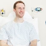 Male patient on hospital bed smiling