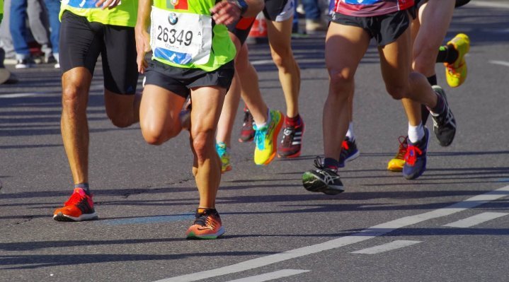 closeup marathon runners in competition road bright trainers