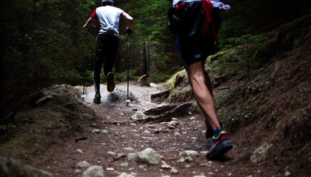 two men running forest rough terrain